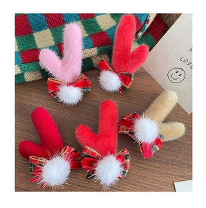 Détail de pinces à cheveux bois de renne avec nœuds en peluche sur fond bois