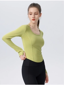 Detail of teal long sleeve yoga top featuring slimming curved hem and breathable fabric