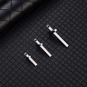 Polished silver stainless steel cross bar pendants in three sizes on black mesh background
