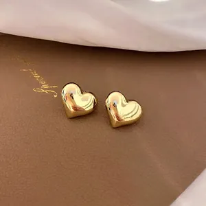 Elegant 3D heart-shaped gold stud earrings with a high-polished metallic mirror finish