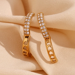 Macro view of 18K gold hoop earring with micro-pave zircons and hollow heart details