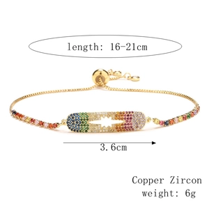 Detail of adjustable copper bracelet with colorful rainbow zircon stones and capsule pendant