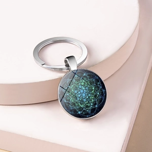 Detailed top view of a silver keychain with a blue and green mandala glass dome