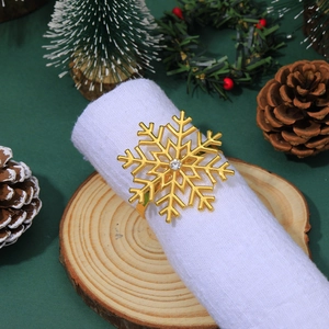 Close-up of golden snowflake napkin ring with rhinestone on white fabric decoration