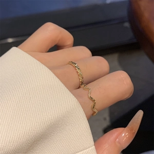 Gold plated twisted ring and wavy zircon set worn on finger with elegant minimalist design
