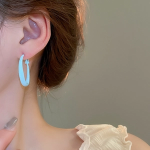 Close-up of a minimalist light blue hoop earring worn on model for casual spring style
