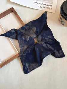 Close-up of vintage navy blue tie-dye silk scrunchie with soft cloud-like texture