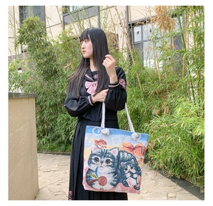 Detail of canvas tote bag featuring cat jacquard embroidery and thick cotton rope handles