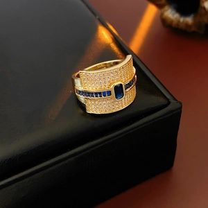 Macro detail of gold plated ring featuring rectangular blue stones and pavé set zircons
