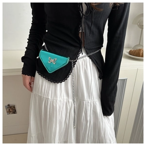 Détail du mini sac triangle vert métallisé avec chaîne argentée et décor de papillon