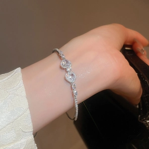 Detailed view of luxury zircon heart-shaped bracelet on model's wrist with silver finish