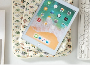 Detail of floral quilted cotton sleeve for iPad and laptop on a clean white desk