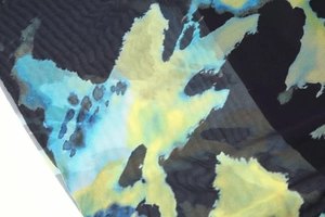 Gros plan sur tissu en maille respirant avec motifs floraux abstraits bleu et jaune