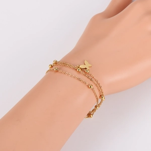 Gold layered stainless steel bracelet featuring small beads and butterfly pendant