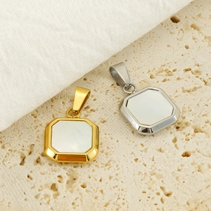 Macro view of gold and silver square pendants with white mother of pearl inlay on stone