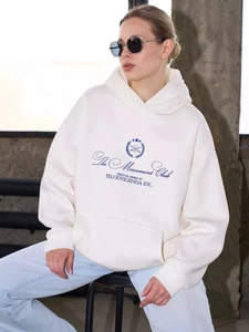 Detail of cream oversized hoodie with blue The Movement Club print and kangaroo pocket
