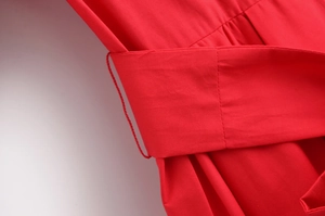 Macro view of bright red poplin dress waist belt loop and precise stitching detail
