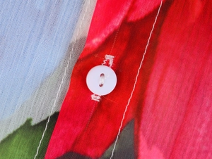 Macro detail of white round buttons on floral chiffon shirt with high-quality stitching