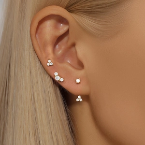 Close-up of gold S925 silver stud earrings set with clear cubic zirconia on ear