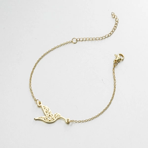 Close-up of golden hummingbird charm bracelet with adjustable chain and lobster clasp