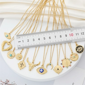 Golden stainless steel necklace set featuring Evil Eye, Cross, and Moon charms on a tray