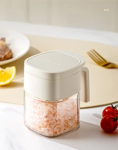 Detail of glass spice jar with cream handle showing moisture-proof lid and clear body