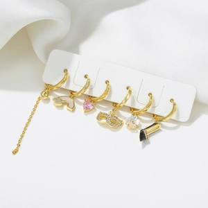 Golden heart earring set with black high heel and zircon charms on display
