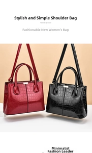 Detail of burgundy and black glossy embossed faux crocodile leather handbags with gold hardware