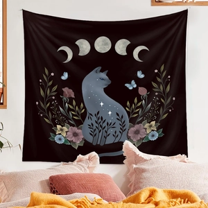 Detail of mystery cat tapestry featuring moon phases and flowers in a cozy bedroom setting