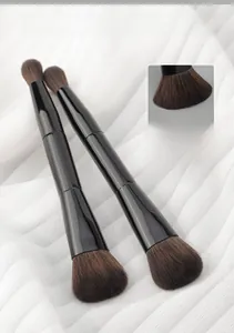 Close-up of dual-ended makeup brushes with soft synthetic bristles and black glossy handles