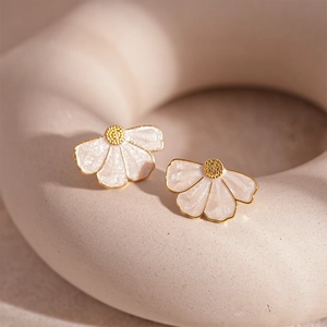 Macro detail of fan-shaped stud earrings with gold edges and pearlescent petals