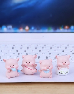Set of four cute pink resin pig ornaments placed on a laptop keyboard for car or desk