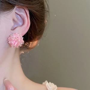Nahaufnahme eines rosafarbenen Kristall-Ohrsteckers in Blumenform für einen süßen Look