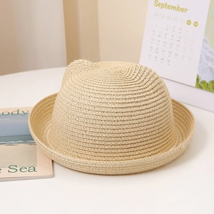 Gros plan d'un chapeau en paille beige pour enfants avec oreilles de chat mignonnes
