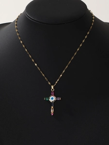 Detail of gold cross necklace with evil eye motif and colorful rectangular gemstones