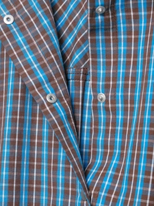 Détail de la robe à carreaux bleu et marron montrant le tissu et les boutons argentés