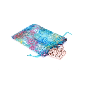 Detail of blue organza drawstring gift bag with pink coral pattern and heart charm
