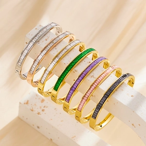 Stack of vintage titanium steel bracelets with colorful square zircons on stone stand