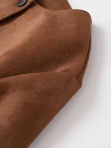 Vue détaillée du tissu en daim marron de la veste avec un bouton de fermeture noir en résine