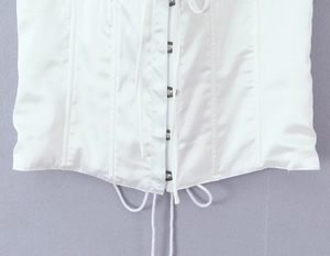 Détail du haut corset en satin blanc avec fermeture à agrafes et lacets réglables