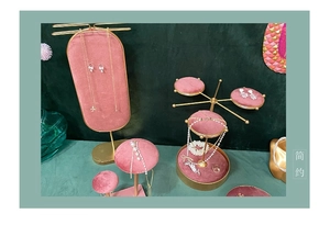 Detail of pink velvet jewelry display stand featuring pearl necklaces and gold earrings