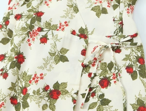 Detail of waist tie and red rose floral print on cream vintage long sleeve dress