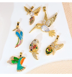 Detailed view of six assorted gold-plated bird and angel wing pendants with zircons