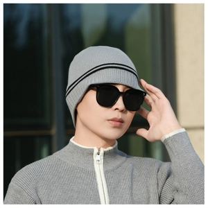 Detailed close-up of grey knitted beanie with double black stripes for winter warmth