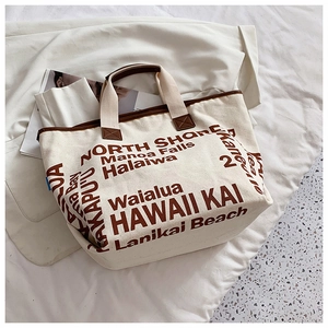 Detail einer cremefarbenen Canvas-Tragetasche mit braunem Rand und Hawaii-Aufdruck