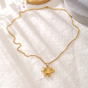 Close-up of golden hip hop necklace featuring a unique one-eyed monster pendant