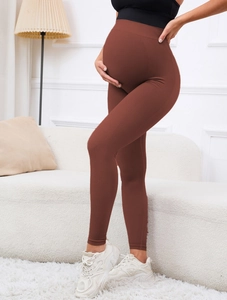 Close-up of high-waist maternity leggings in brown with stretchy belly support fabric