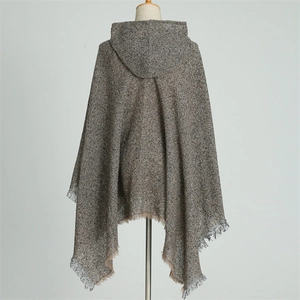 Back view of brown and grey plaid knit poncho with hood and decorative tassel hem