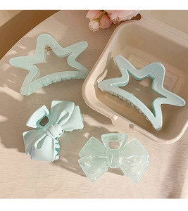 Detail view of light blue star and bow hair claws set on a decorative background