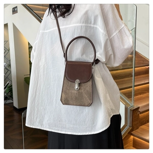 Brown leather crossbody bag with mixed textures shown on model in a casual outdoor setting